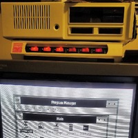 An IBM PCjr on top of a monitor displaying the Windows 3 program manager